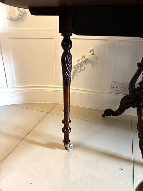 fig 2. An antique Victorian rosewood Sutherland table with drop leaves, carved legs, and brass castors.