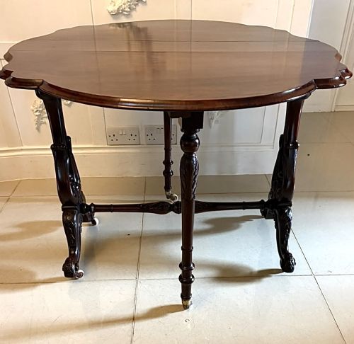 fig 3. An antique Victorian rosewood Sutherland table with drop leaves, carved legs, and brass castors.