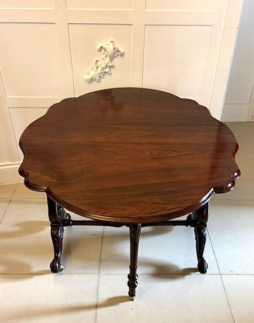 fig 4. An antique Victorian rosewood Sutherland table with drop leaves, carved legs, and brass castors.