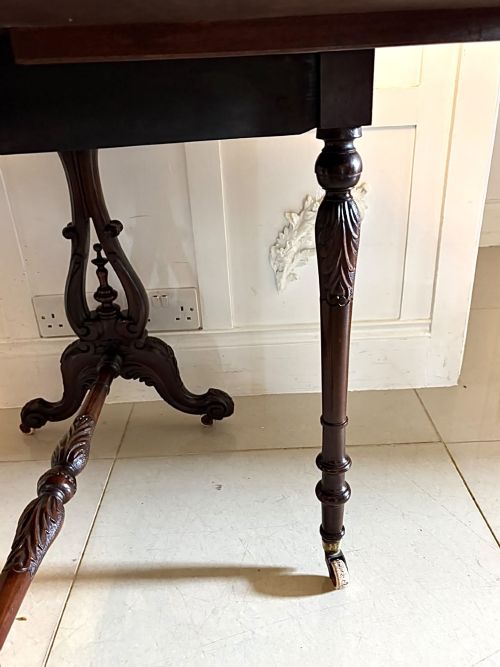 fig 5. An antique Victorian rosewood Sutherland table with drop leaves, carved legs, and brass castors.