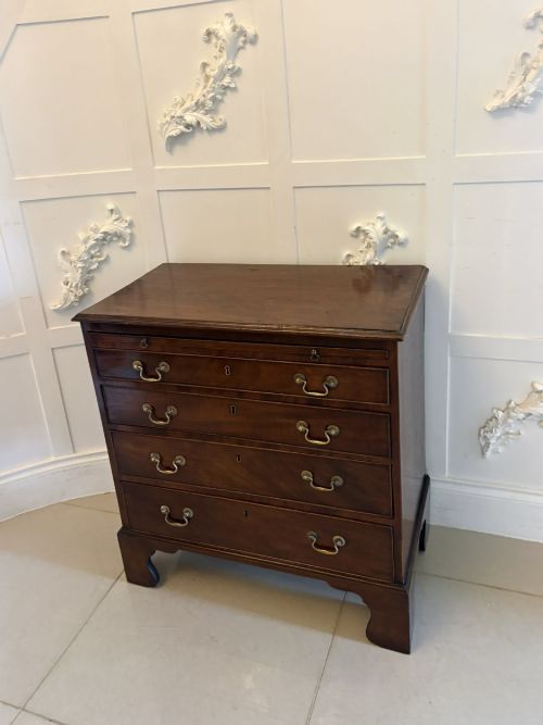 fig 3. A small Georgian mahogany chest of drawers featuring four graduated drawers with brass swan-neck handles, a pull-out brushing slide, and bracket feet.