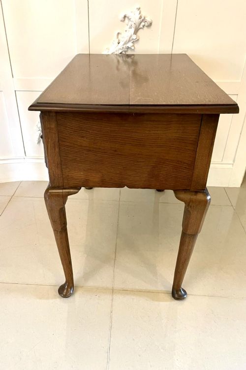 An 18th-century George III oak lowboy featuring three drawers with brass swan-neck handles, a shaped apron, and cabriole legs ending in pad feet. View IX