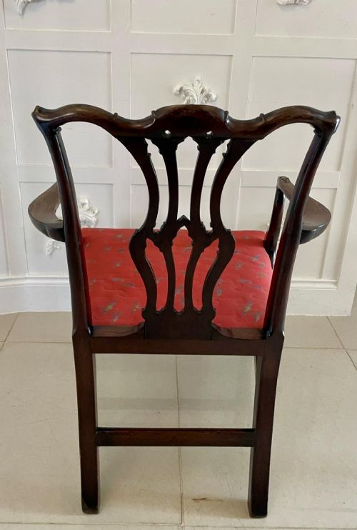 A set of twelve carved dark mahogany dining chairs featuring intricate pierced back splats and red patterned upholstered seats. View V