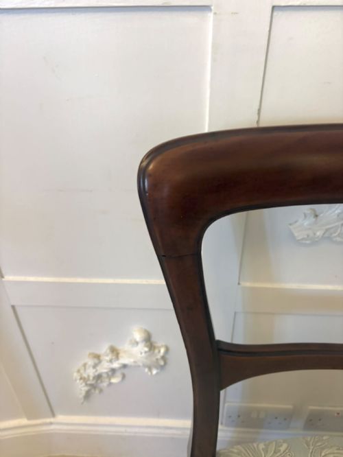 fig 4. Set of six Victorian mahogany dining chairs featuring curved open backrests, reeded front legs, and light blue pattern-upholstered seats.