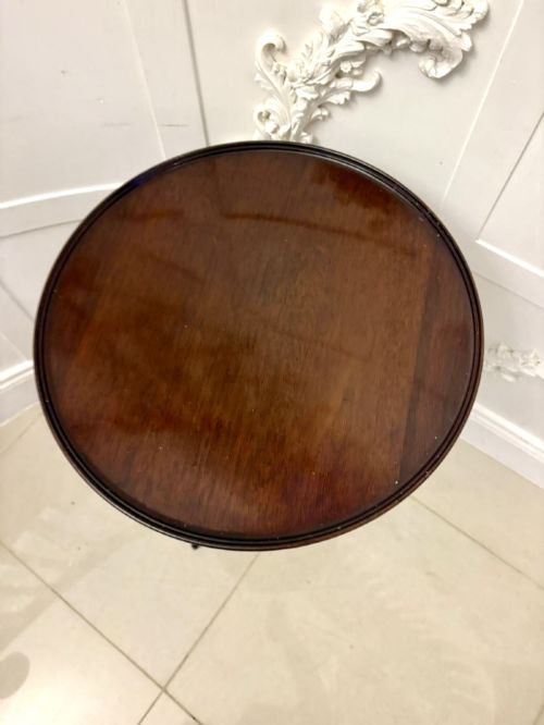 fig 1. A circular dark mahogany tripod table featuring a moulded rim, turned baluster column, and three shaped legs.