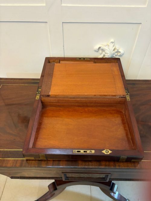 fig 3. A rectangular Victorian mahogany writing box featuring brass corner brackets, vertical brass strapping, a central brass shield inlay, and a brass keyhole escutcheon.