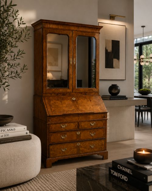 fig 2. An 18th-century George I figured walnut bureau bookcase featuring two mirrored upper cabinet doors, a slant-front writing desk, and three lower drawers on bracket feet.