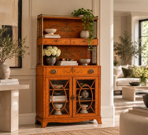 fig 1. A Georgian Sheraton style satinwood display cabinet featuring upper open shelves with brass grilles and marquetry panels, positioned above a lower glazed twin-door cabinet with oval astragal bars.
