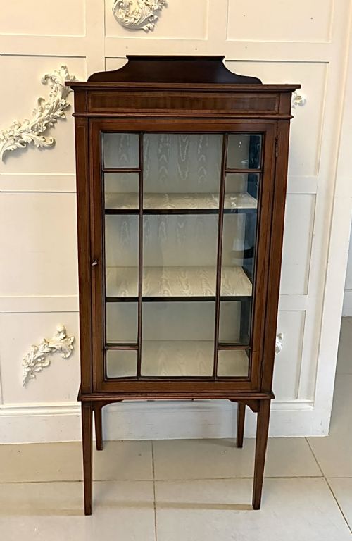 An Edwardian mahogany glazed display cabinet featuring geometric glazing bars, tapered legs, a raised pediment top, and a light-lined interior with three shelves. View IX