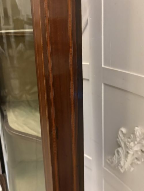 fig 4. An Edwardian mahogany corner display cabinet with a serpentine glazed door, line inlay decoration, shaped upper pediment, and slender tapered legs with a lower undertier.