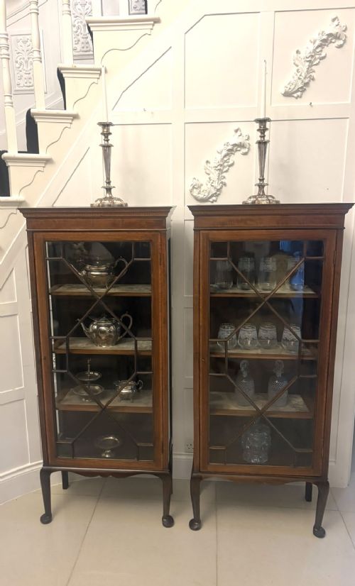 fig 4. A pair of tall Edwardian mahogany display cabinets with geometric astragal glazed glass doors and slender cabriole legs.