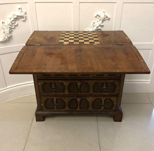 fig 6. A George I yew wood and laburnum oyster veneered bachelors chest of drawers with carved corner caryatids and brass drop handles.