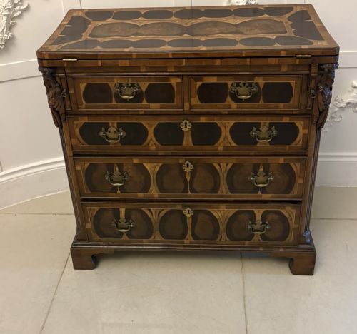 fig 1. A George I yew wood and laburnum oyster veneered bachelors chest of drawers with carved corner caryatids and brass drop handles.