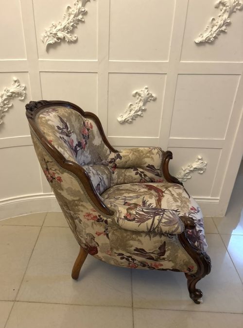 fig 3. An antique Victorian carved rosewood armchair featuring floral and bird pattern upholstery with cabriole legs on castors.