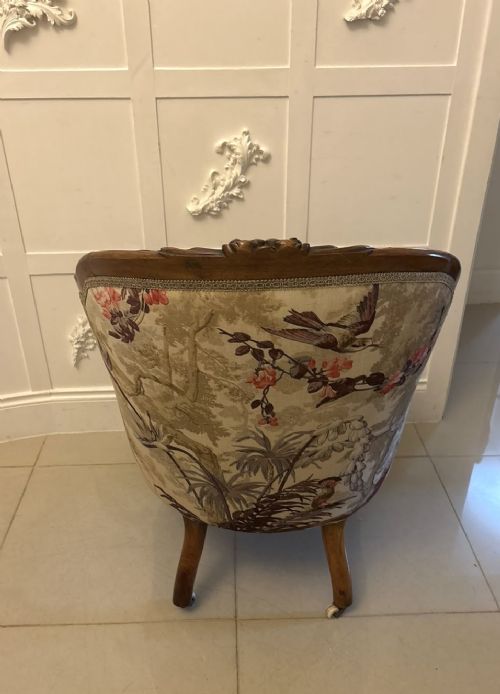 fig 4. An antique Victorian carved rosewood armchair featuring floral and bird pattern upholstery with cabriole legs on castors.
