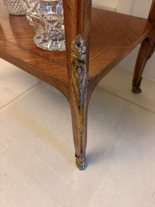 fig 2. An antique French Napoleon III satinwood bijouterie table featuring a glazed display top, curved cabriole legs with decorative brass mounts, and an undertier shelf.