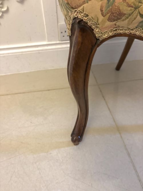 fig 3. A set of four Victorian carved walnut dining chairs featuring open balloon backs, carved crest details, cabriole front legs, and floral pattern upholstered seats.