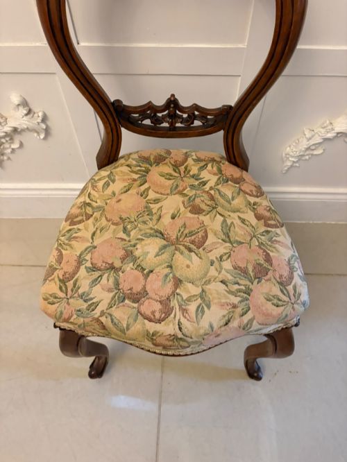 fig 4. A set of four Victorian carved walnut dining chairs featuring open balloon backs, carved crest details, cabriole front legs, and floral pattern upholstered seats.
