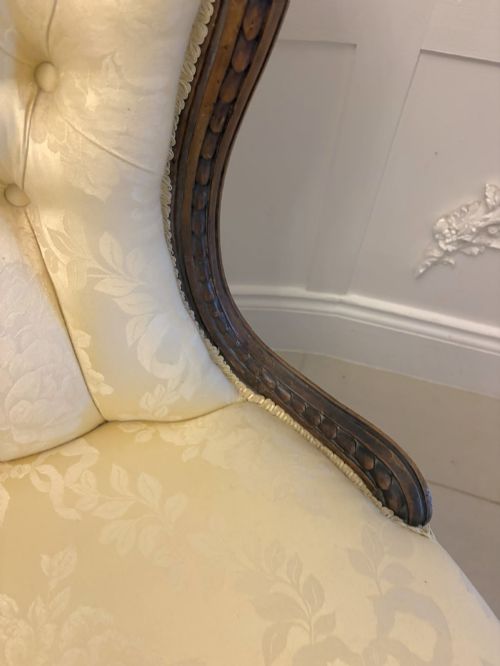 fig 3. A Victorian carved walnut slipper chair featuring a button-tufted cream damask spoon-shaped backrest and cabriole front legs.