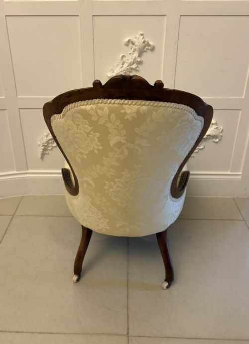 A Victorian carved walnut slipper chair featuring a button-tufted cream damask spoon-shaped backrest and cabriole front legs. View XIII