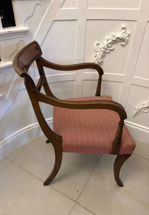fig 3. An antique mahogany carver dining chair with sweeping armrests, a carved central roundel crest bar, and a pink patterned upholstered seat.