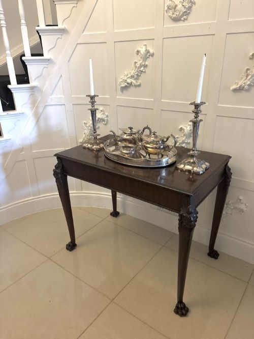 fig 4. A George III mahogany centre table featuring a rectangular flat top, deep apron, and four carved legs ending in claw and ball feet.