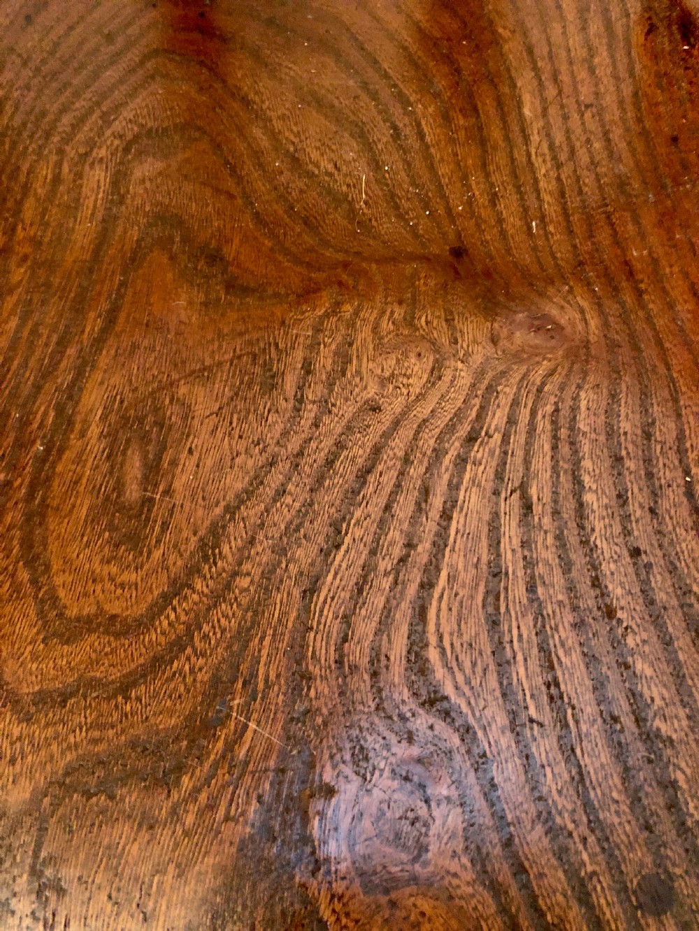 An antique dark oak captains desk chair featuring a curved crest rail, turned spindles, a contoured saddle seat, and sturdy turned legs. View II