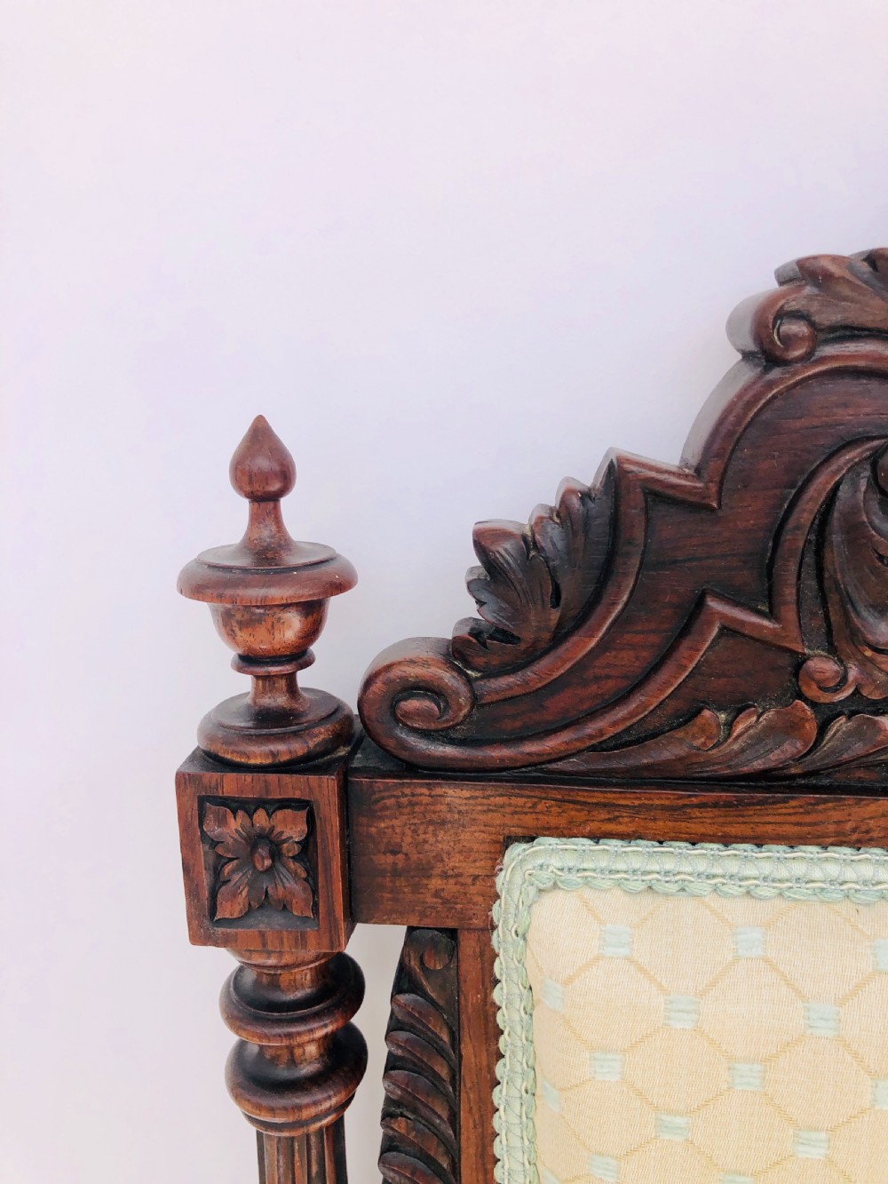 A Victorian carved rosewood side chair featuring a high back with ornate carved cresting, turned side columns, and light cream pattern upholstered seating. View II