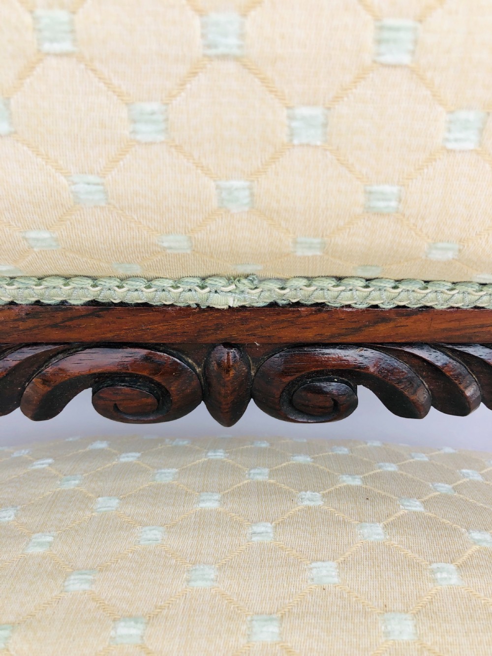 A Victorian carved rosewood side chair featuring a high back with ornate carved cresting, turned side columns, and light cream pattern upholstered seating. View V