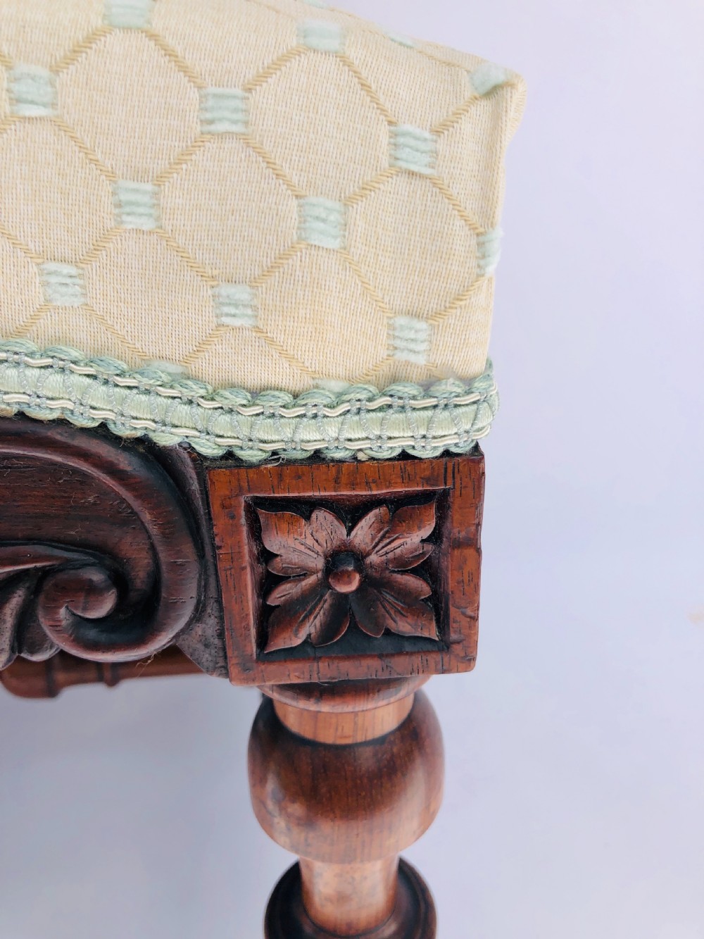 A Victorian carved rosewood side chair featuring a high back with ornate carved cresting, turned side columns, and light cream pattern upholstered seating. View VI