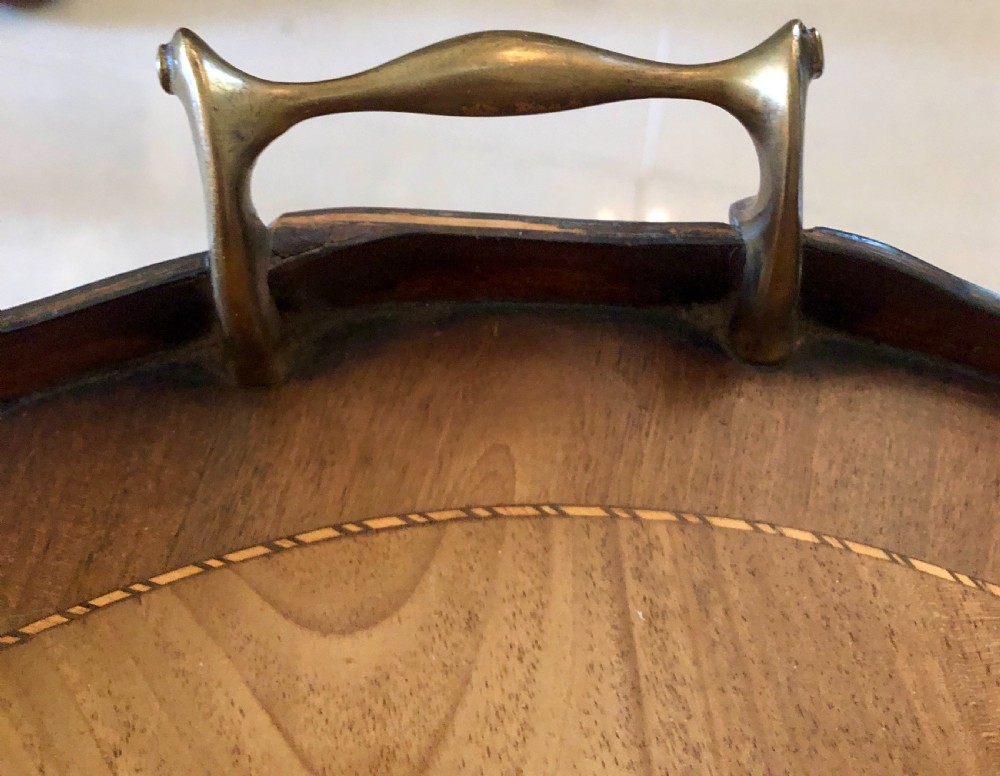 An Edwardian oval mahogany tray table with brass carrying handles, satinwood inlay, tapered legs, and a lower circular tier. View III