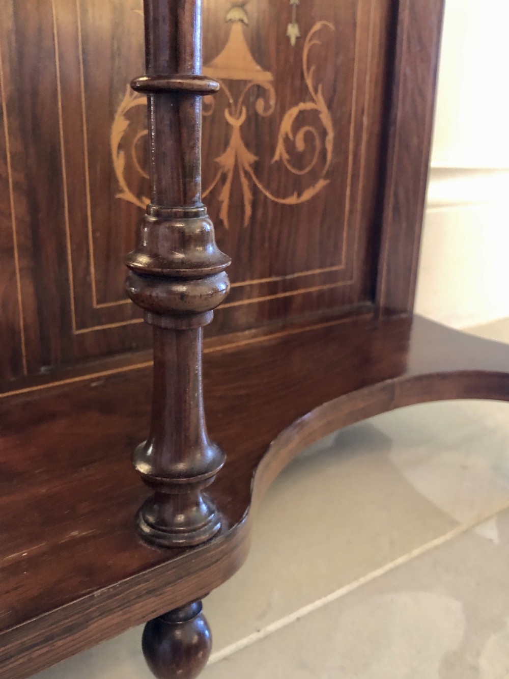 An Edwardian rosewood overmantel mirror featuring detailed bow and urn marquetry inlays, turned supporting columns, and a central rectangular glass plate. View V