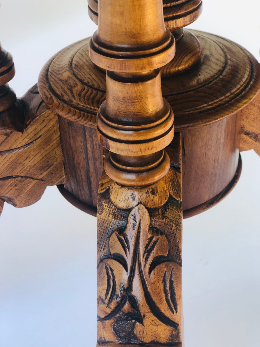 An oval Victorian walnut centre table featuring floral marquetry inlays on the top, supported by turned central columns and four carved legs on castors. View VI