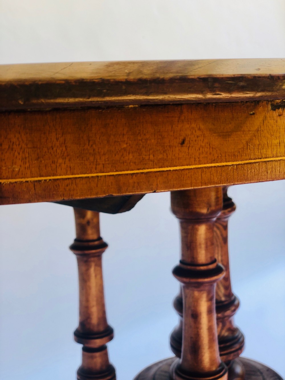 An oval Victorian walnut centre table featuring floral marquetry inlays on the top, supported by turned central columns and four carved legs on castors. View VIII