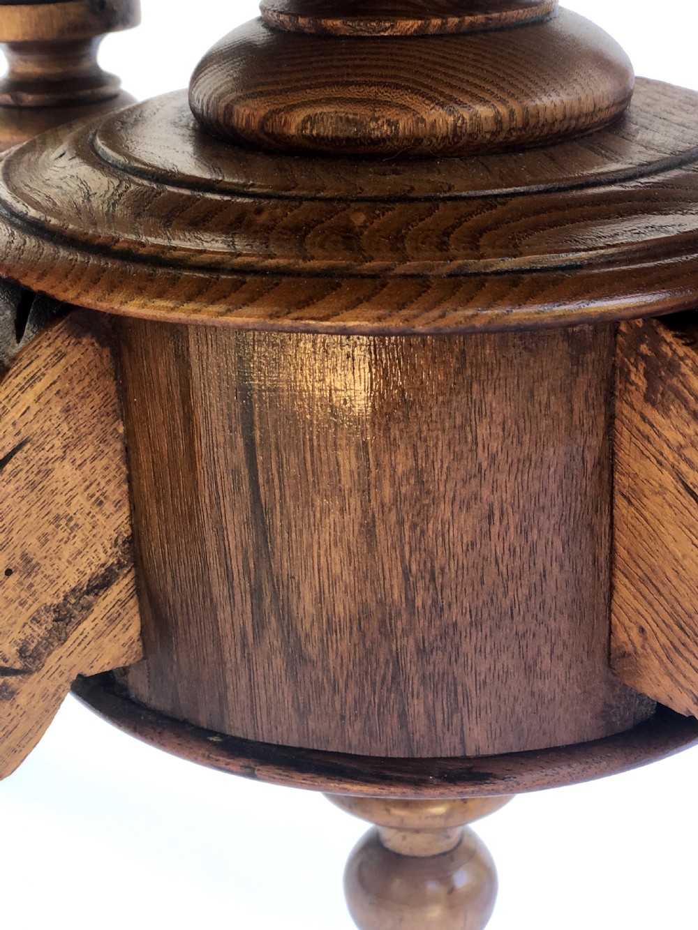 An oval Victorian walnut centre table featuring floral marquetry inlays on the top, supported by turned central columns and four carved legs on castors. View IX