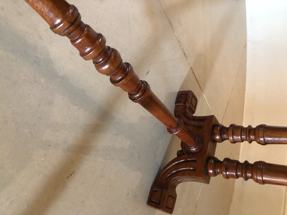 A Victorian walnut Sutherland table with drop leaves folded down, set on turned legs and ceramic castors. View VI