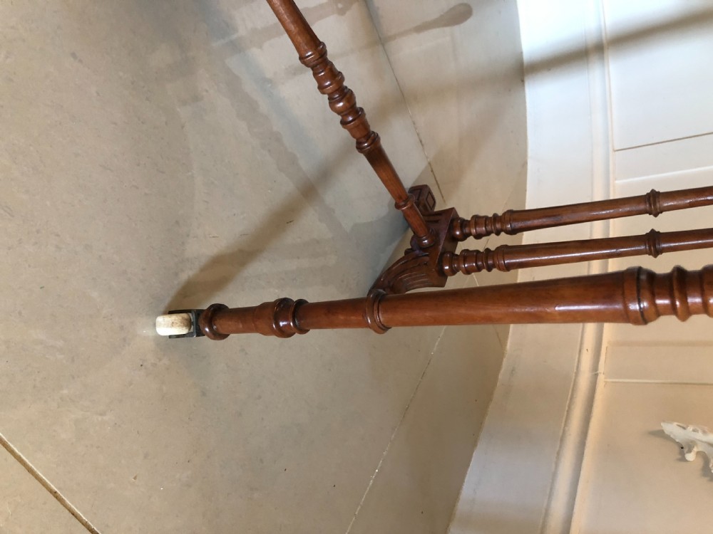 A Victorian walnut Sutherland table with drop leaves folded down, set on turned legs and ceramic castors. View VII