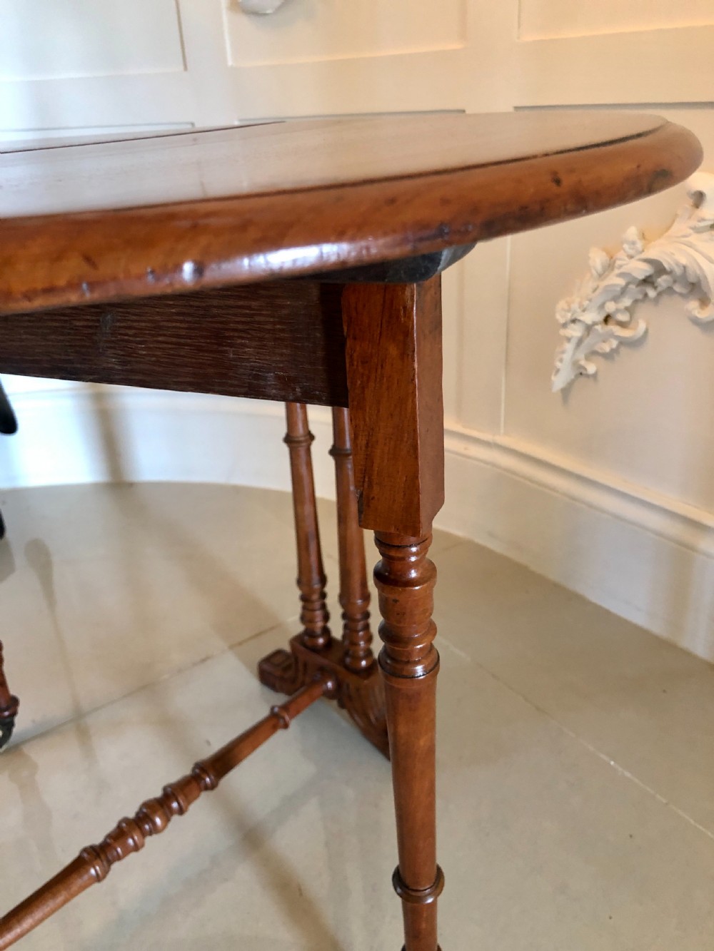 A Victorian walnut Sutherland table with drop leaves folded down, set on turned legs and ceramic castors. View XI
