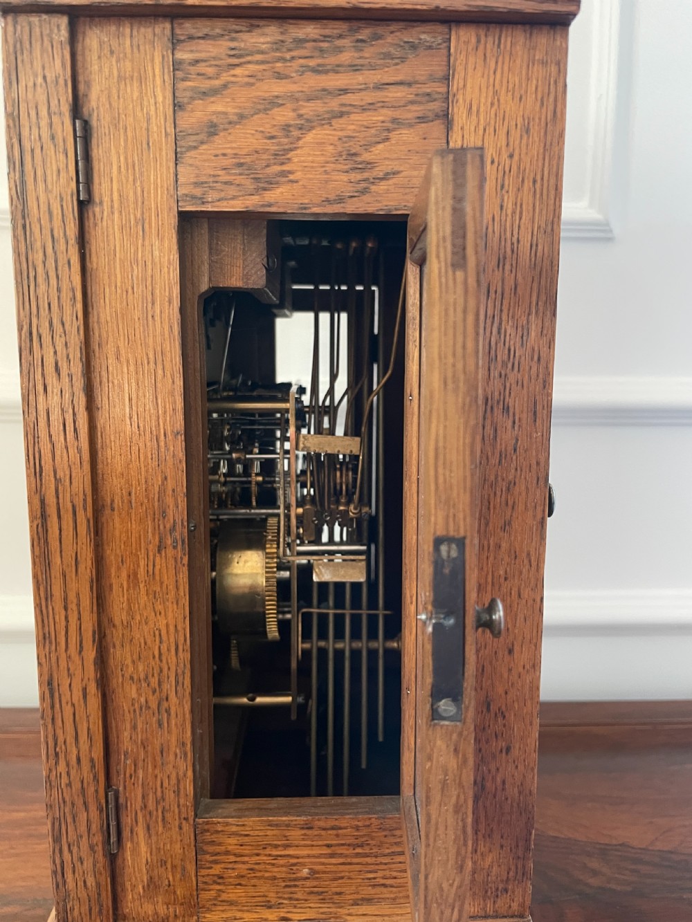 A Victorian carved oak bracket clock featuring a silvered engraved dial with Roman numerals, a chime-silent secondary dial, and carved gadrooned detailing along the top base. View V