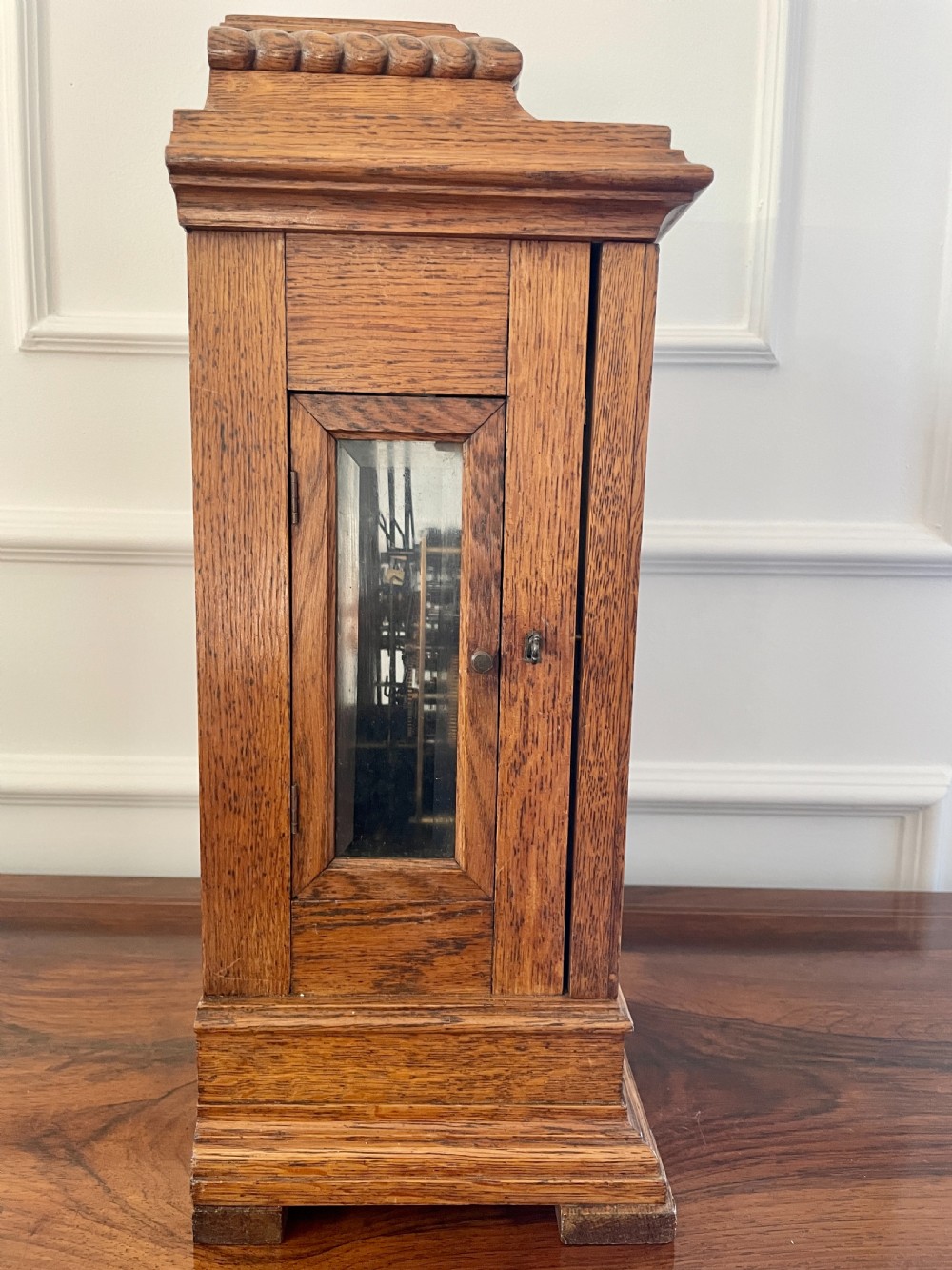 A Victorian carved oak bracket clock featuring a silvered engraved dial with Roman numerals, a chime-silent secondary dial, and carved gadrooned detailing along the top base. View X