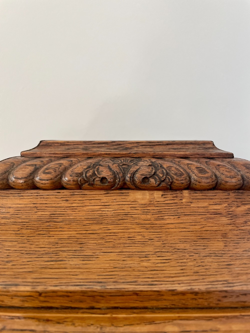A Victorian carved oak bracket clock featuring a silvered engraved dial with Roman numerals, a chime-silent secondary dial, and carved gadrooned detailing along the top base. View XIII
