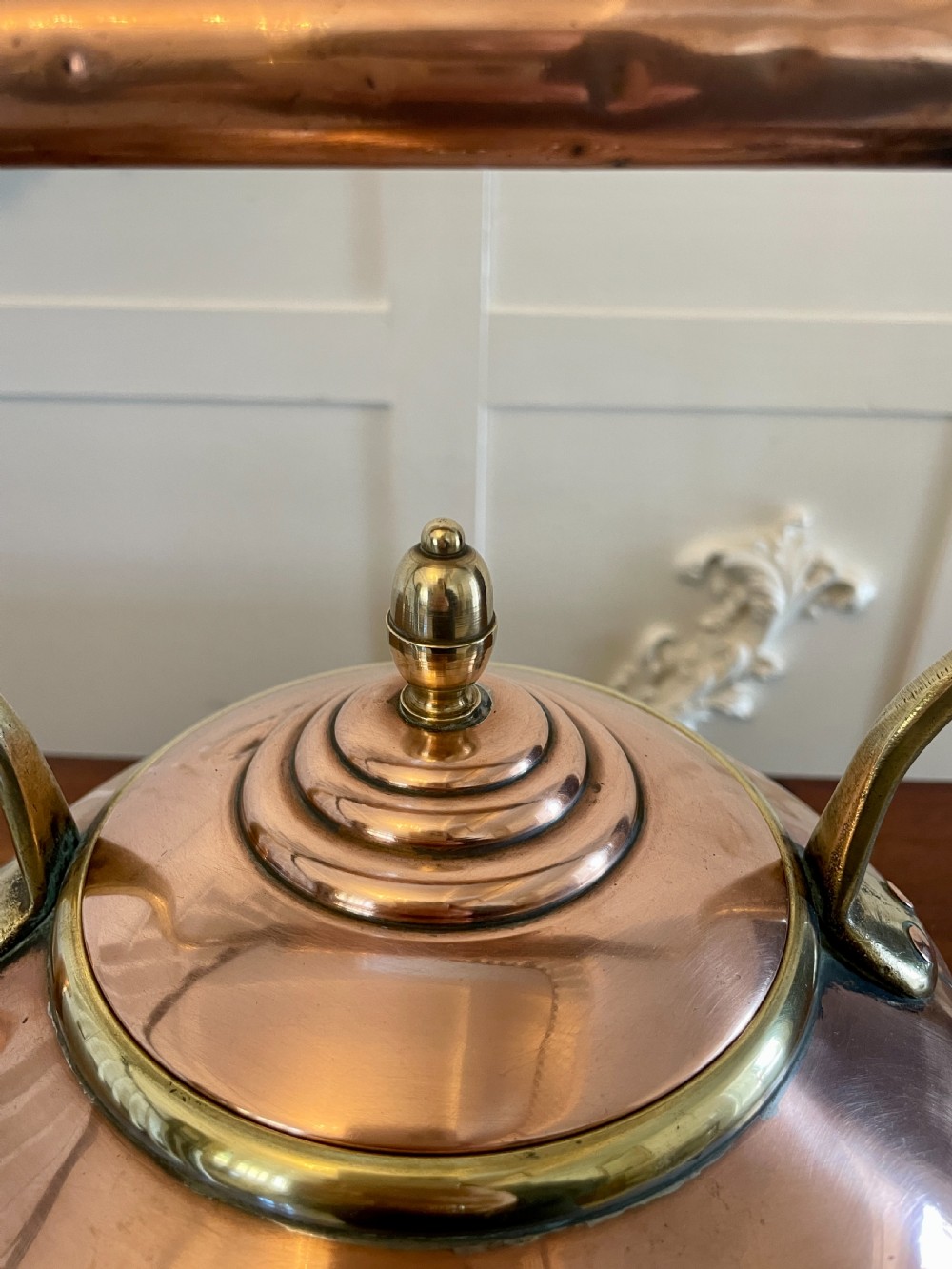 A George III copper tea kettle featuring a brass-accented overhead handle, a gooseneck spout, and a stepped lid with a brass finial. View VII