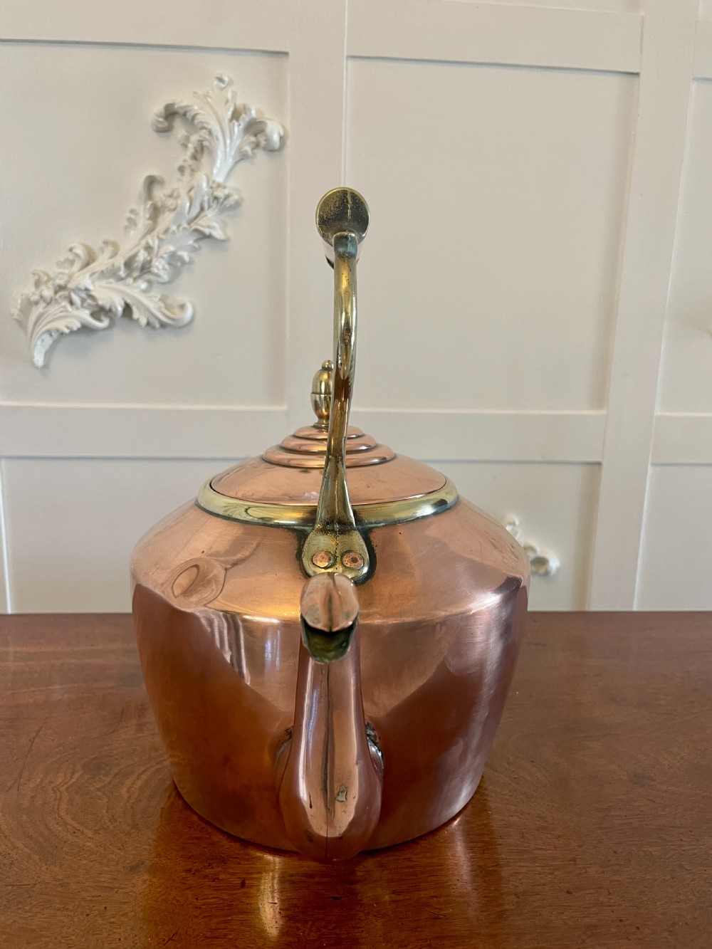 A George III copper tea kettle featuring a brass-accented overhead handle, a gooseneck spout, and a stepped lid with a brass finial. View VIII