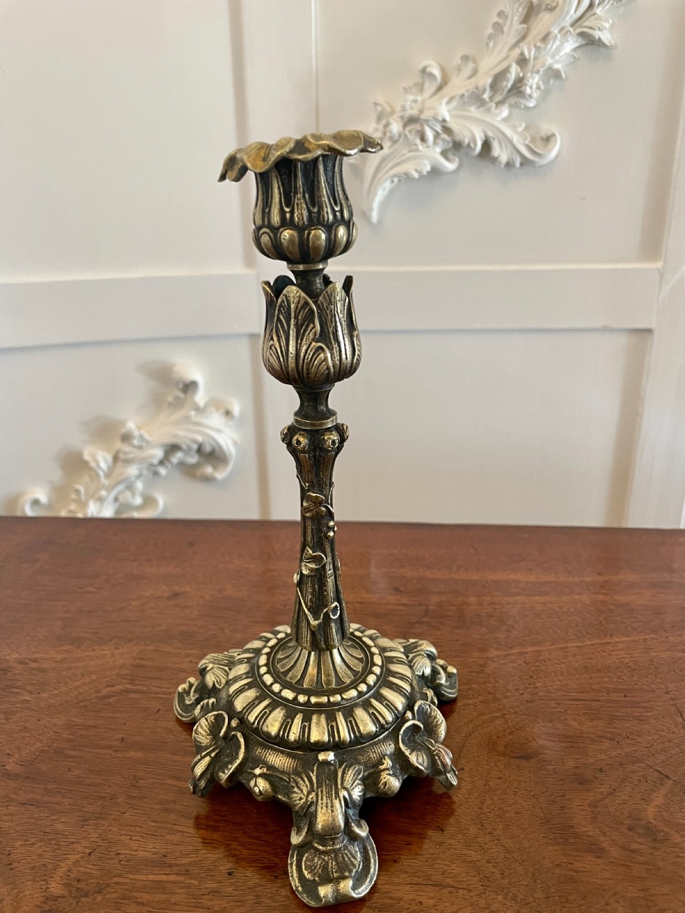 A pair of ornate brass candlesticks featuring intricate foliage carving, fluted stems, and scalloped candle sockets. View III