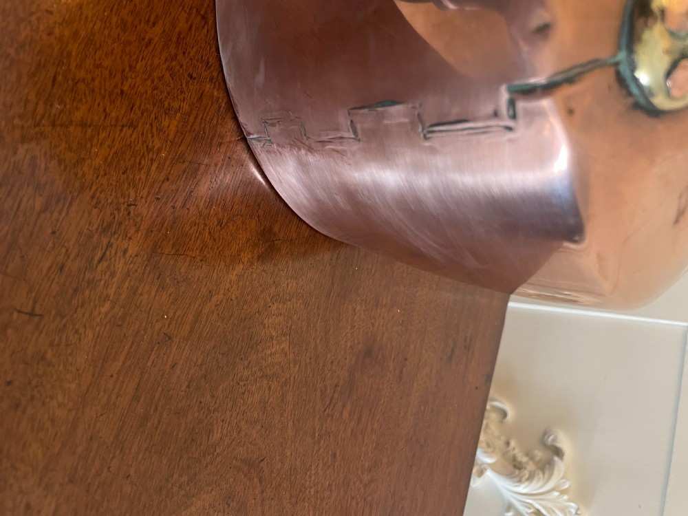 A George III copper tea kettle featuring brass handle mounts, an acorn finial, and a curved spout. View II