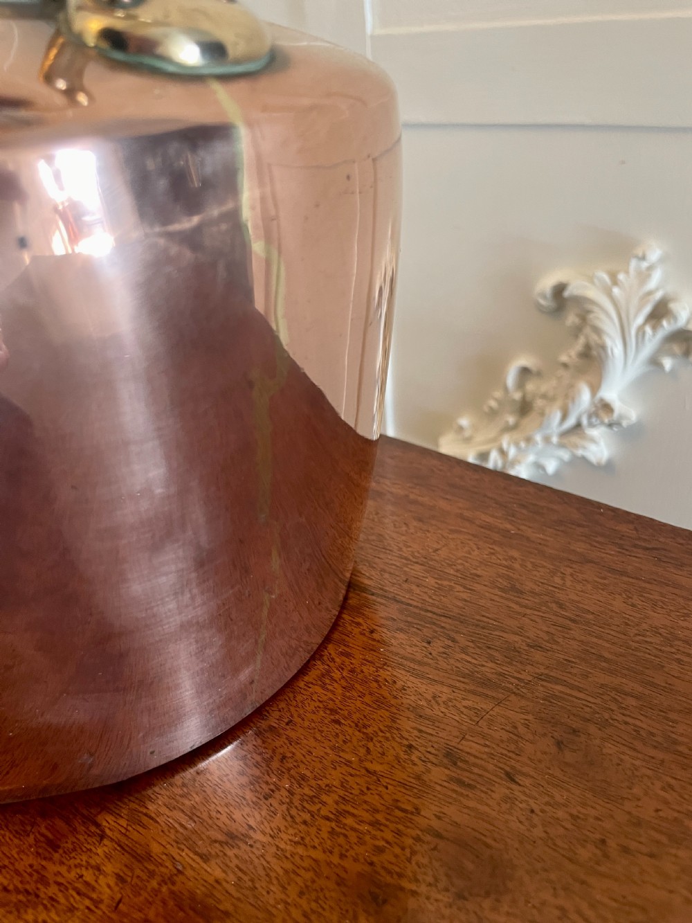 A George III copper tea kettle featuring brass handle mounts, an acorn finial, and a curved spout. View III