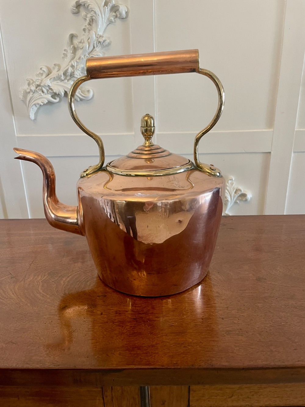 A George III copper tea kettle featuring brass handle mounts, an acorn finial, and a curved spout. View VI