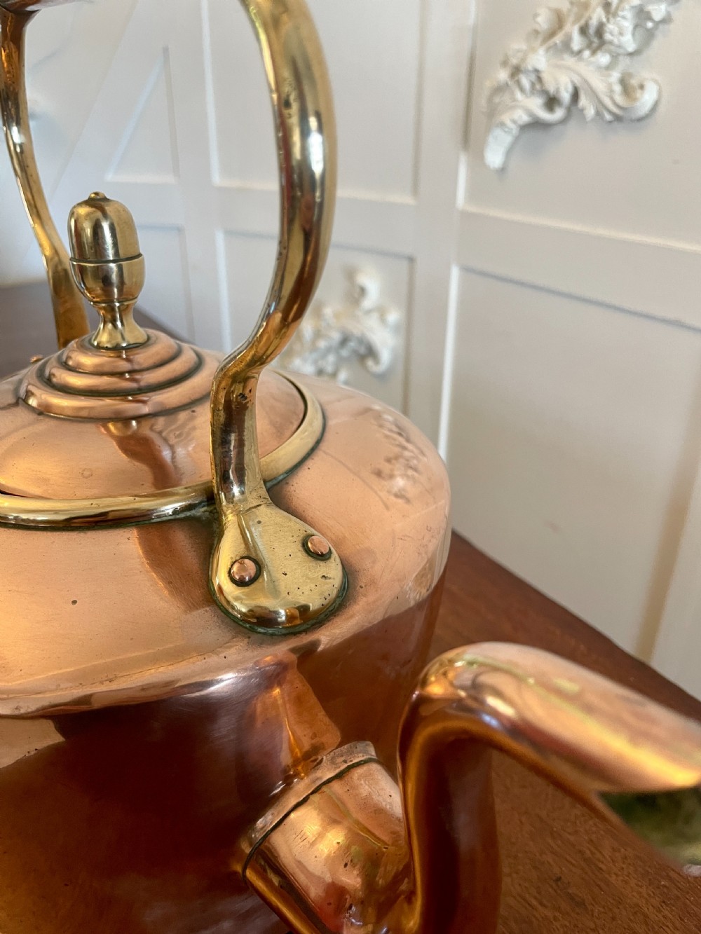 A George III copper tea kettle featuring brass handle mounts, an acorn finial, and a curved spout. View VII
