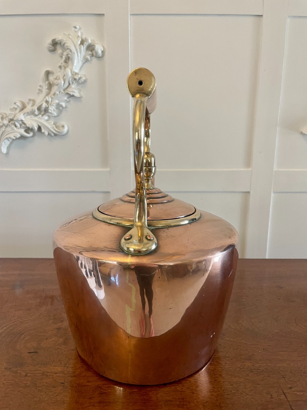 A George III copper tea kettle featuring brass handle mounts, an acorn finial, and a curved spout. View VIII