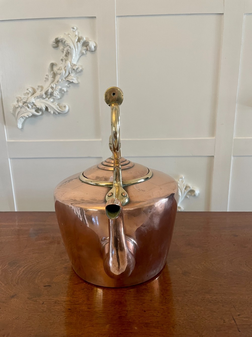 A George III copper tea kettle featuring brass handle mounts, an acorn finial, and a curved spout. View IX